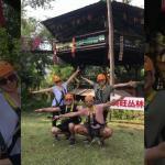 A group of people ziplining in Chiang Mai in front of a sign.